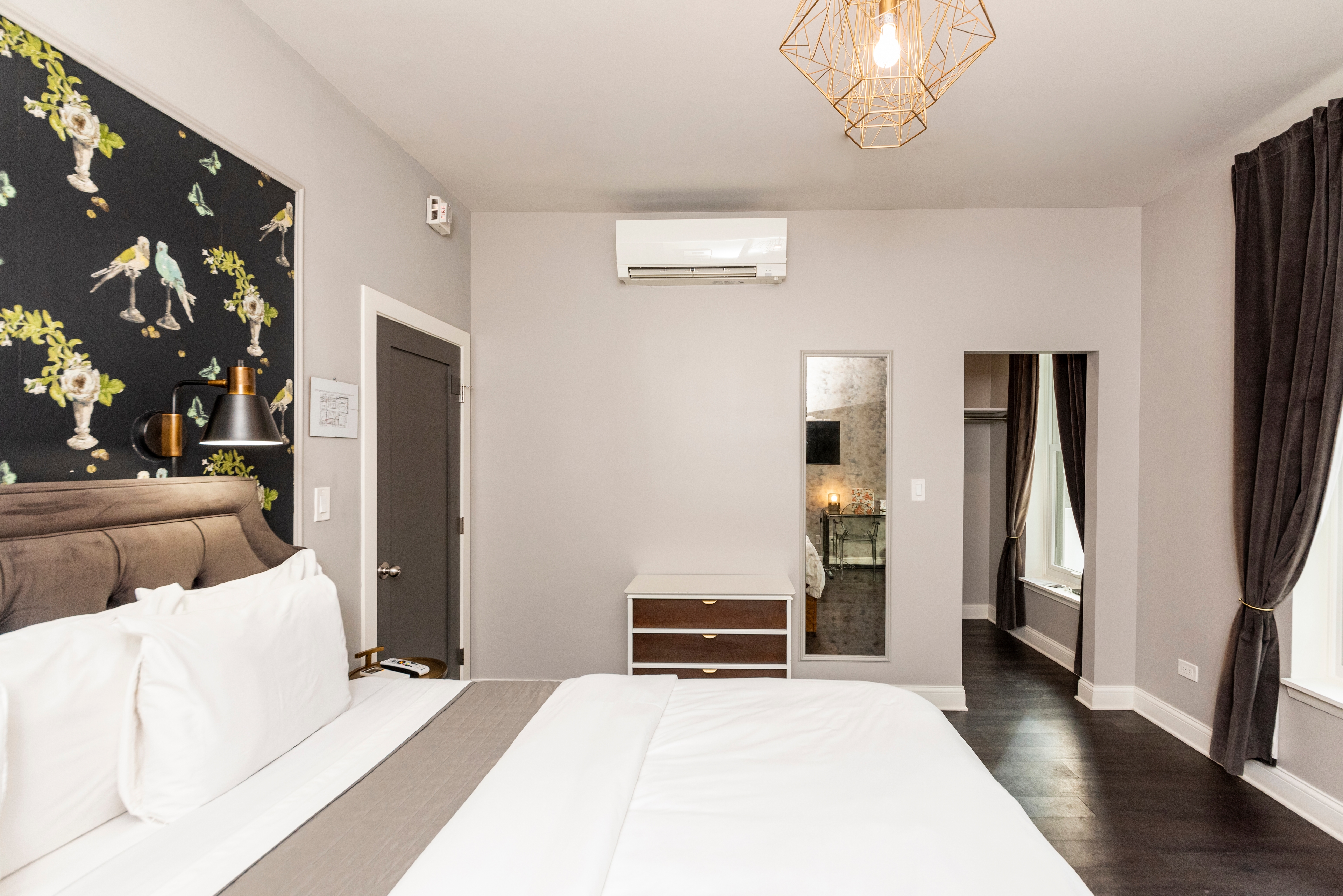 Another angle of the bed, showing the mirror, dresser drawer and doorway.